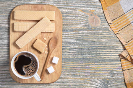 Sweet waffles and cup of hot coffee for breakfast on old wooden table, top view. Space for text