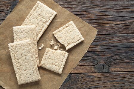 Rye crispbreads on dark wooden table, top view. Dietary food