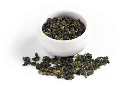 Traditional Chinese Oolong tea in cup and near, on white background. Tie Guan Yin