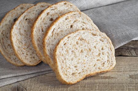 Wheat bread with bran on the wooden table with fabric