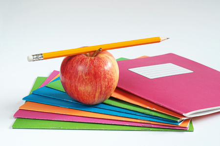 Colored school notebooks with pencil and apple on white background. Education conceptの写真素材
