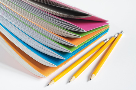 Colored school notebooks with pencils on white background. Education conceptの写真素材