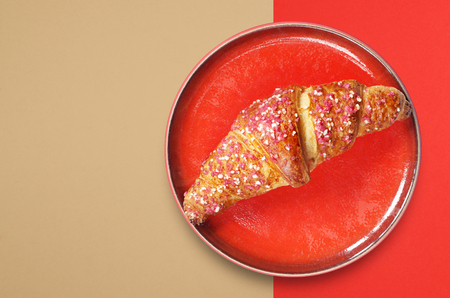 Croissant with raspberry jam in red plate on colorful background, top view with copy spaceの写真素材