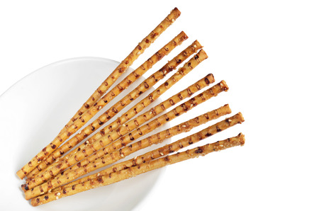 Crispy straw with sesame seeds in bowl isolated on a white background