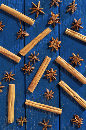Overhead view of anise stars and cinnamon stick on blue wooden backgroundの写真素材