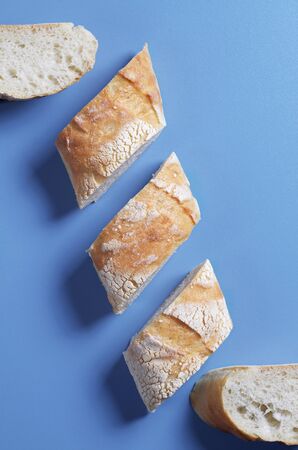 Slices of fresh tasty bread on a blue background, top viewの写真素材