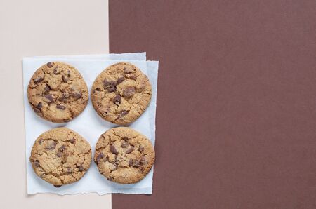 Yummy chocolate chips cookies on two-color background, top view with copy space