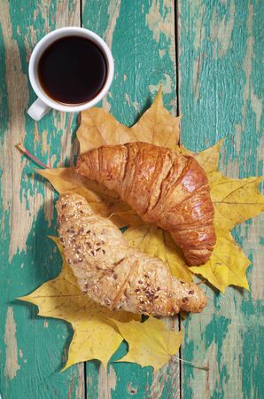 Cup of coffee and two various croissants on an old green wooden background. Top view の写真素材