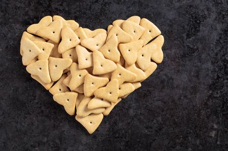 Small sugar-free diet cookies in shape of heart on old black metal background, top view with copy spaceの写真素材
