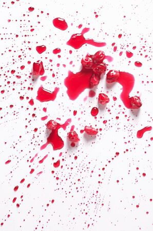 Pomegranate grains and drops of juice on a white background, top view. Abstract backgroundの写真素材