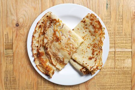 Fried pancakes in plate on old wooden background, top viewの写真素材