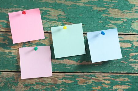 Empty sticky notes on old green wooden background