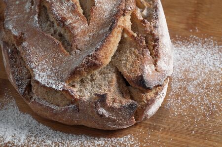 Loaf of homemade rye bread on board close-up