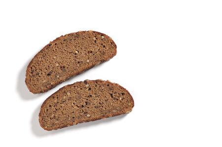 Slices of black rye bread on a white background, top view with copy 