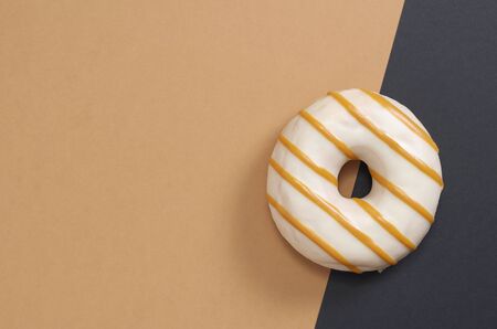 Delicious glazed donut on two-tone background, top view with copy spaceの写真素材