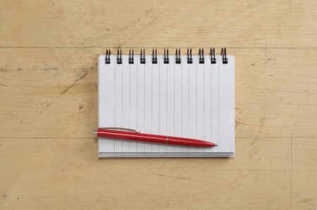 Opened notebook and pen on old wooden background, top viewの写真素材