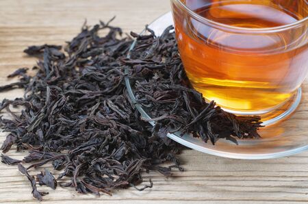 Cup of tea with dried large leaves on a wooden surface. Diet and healthy drinkの写真素材