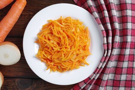 Directly above view of plate with fresh carrot salad with onions on wooden tableの写真素材