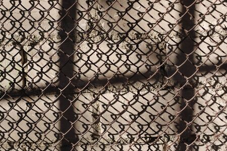 Rusty steel wire mesh on a brick wall. Background texture