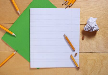 School notebook and pencils on wooden background, top view
