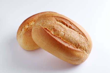 Two loaves of small wheat bread on white background close-up