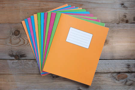 Colorful school notebooks on old wooden table, top view