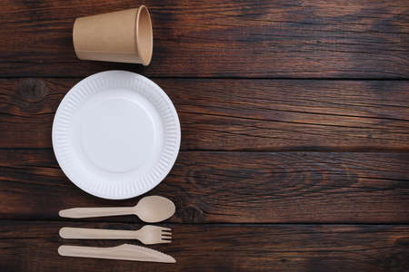 Directly above view of disposable tableware and cutlery on wooden backgroundの写真素材