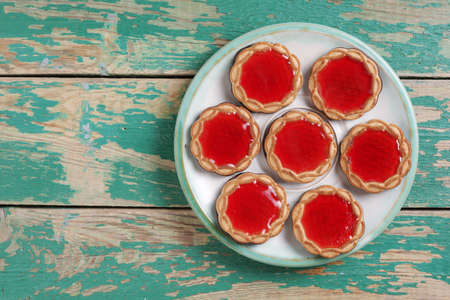 Shortbread cookies with marmalade on a plate on old green wooden background, top view with copy spaceの写真素材