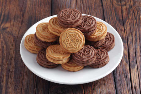 Sandwich-biscuits filled with cream on wooden table close-upの写真素材