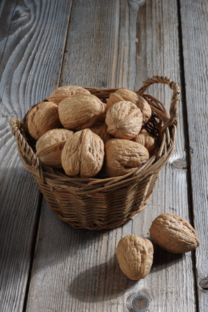 Walnuts in an old wicker basket on a wooden table