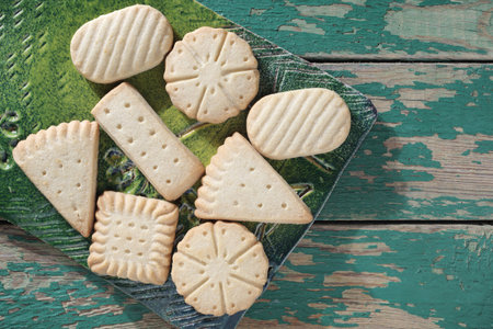Various shortbread cookies on a ceramic board on old green wooden background, top viewの写真素材