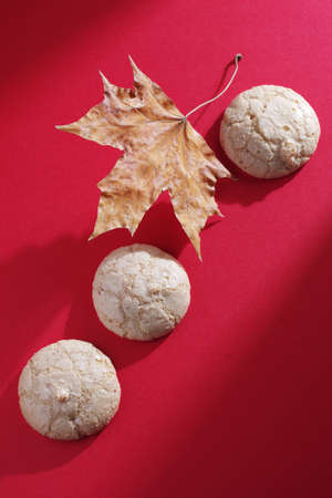 Italian almond cookies on red background, top view