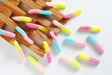 Fruit gummy candy worms on a white background, top view