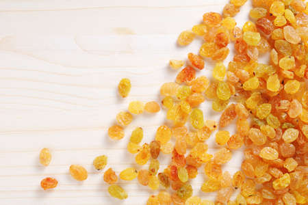 Golden seedless raisins on wooden background, top view with copy spaceの写真素材