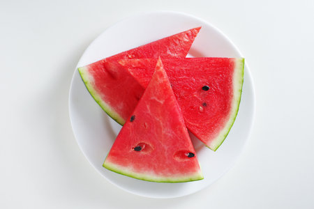 Watermelon slices in plate isolated on white background, top viewの写真素材