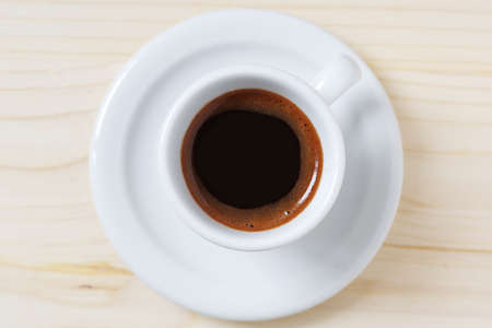 Cup of coffee on wooden background, top viewの写真素材
