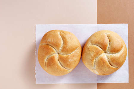 Loaves of small wheat bread on two-tone background, top view with copy spaceの写真素材