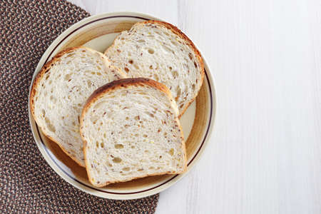 Toast with seeds in a plate on the table, top view with copy space