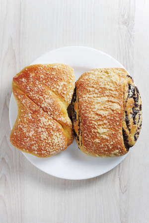 Two fresh sweet buns in plate on the table, top viewの写真素材