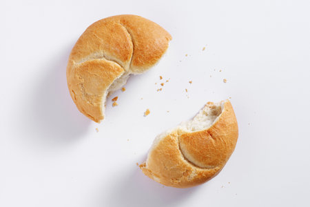 Two half of small wheat bread on white background, top viewの写真素材