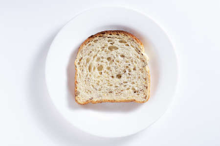Toast with seeds in plate on white background, top viewの写真素材
