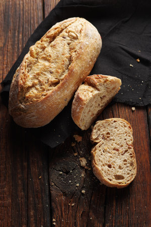 Small rye bread on dark wooden background, top view