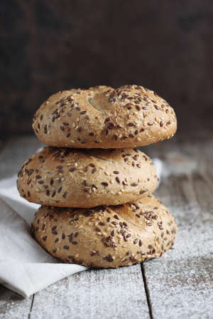 Stack of bread rolls with flax-seeds on the rustic table