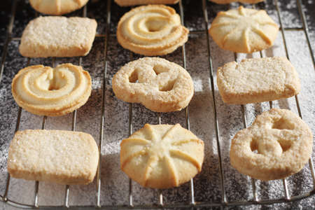 Cookies of various shapes on black metal tray close-up