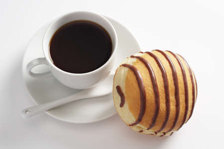 Cup of coffee and donut with chocolate on white background, top viewの写真素材