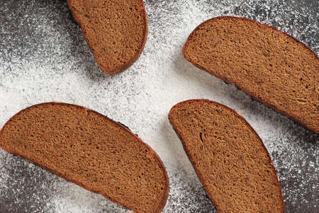Slices of rye bread on a background with flour, top view