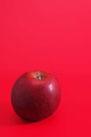 Ripe apple on a red background. Space for textの写真素材