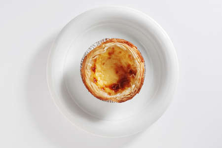 Typical portuguese dessert pie - Pastel de Nata on a plate on a white background, top view