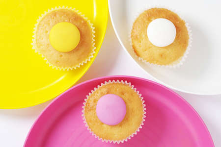 Lemon flavored biscuits in colored plates on white background, top view