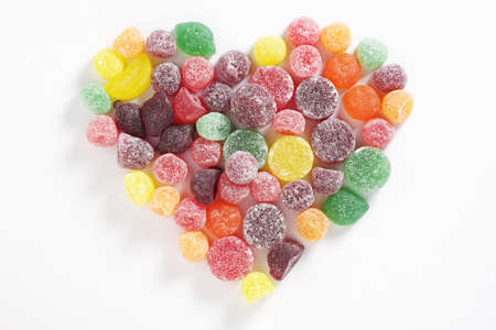 Chewing gum mix with fruit flavor in shape of heart on a white background, top viewの写真素材